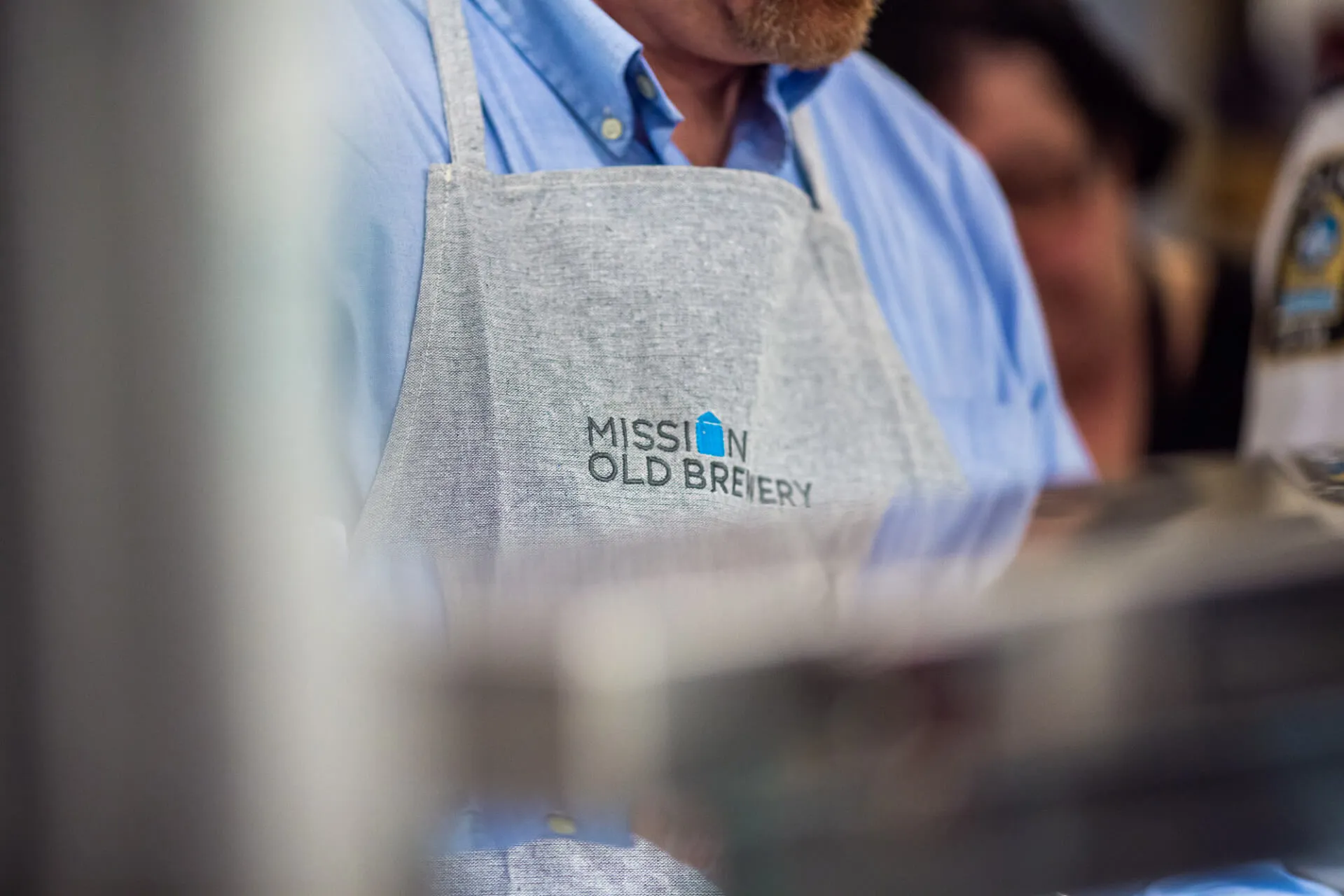 Apron with Old Brewery Mission logo worn by Supper Experience volunteer.