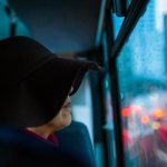 homeless woman looking out of the window in a bus
