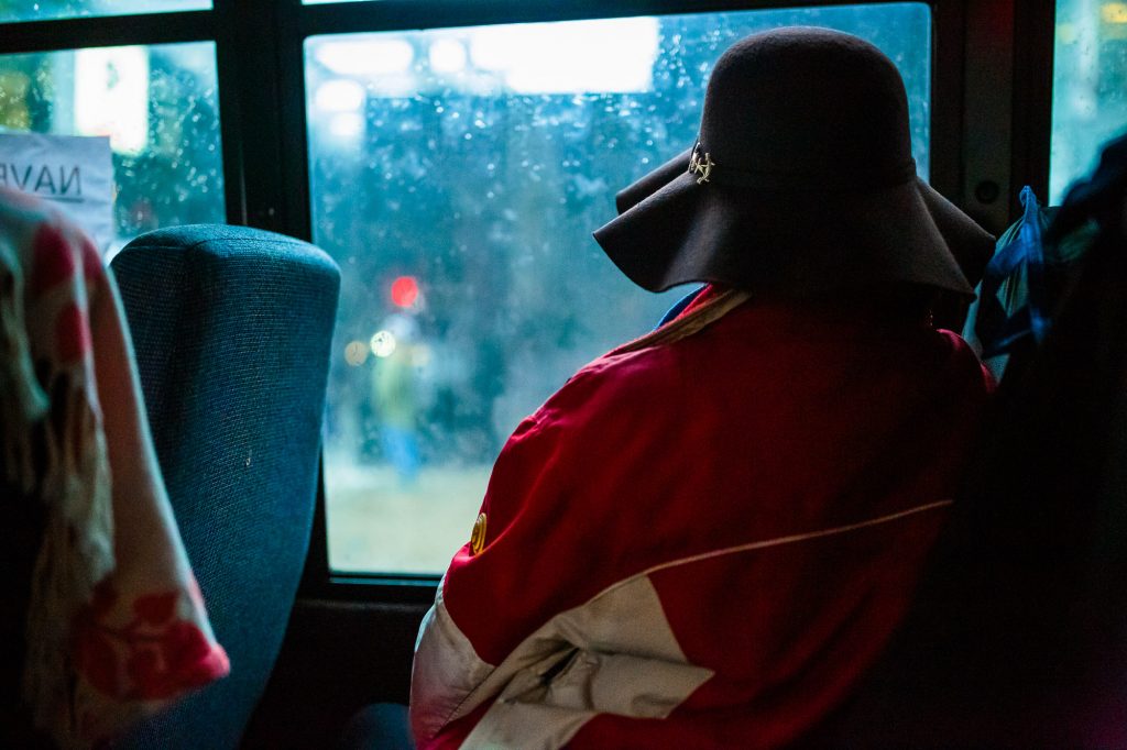 une femme sans-abri dans un autobus portant un chapeau